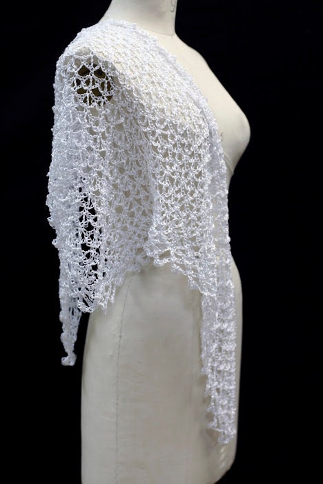 Close-up of the white crochet openwork and beaded edge of the shawl.