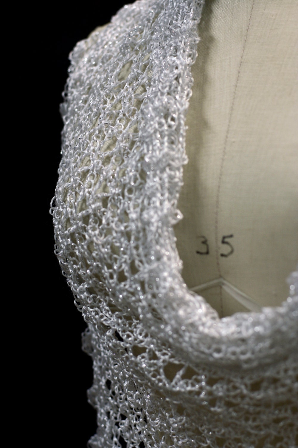 Detail of the hand stitches along the beaded edge of the white shawl.