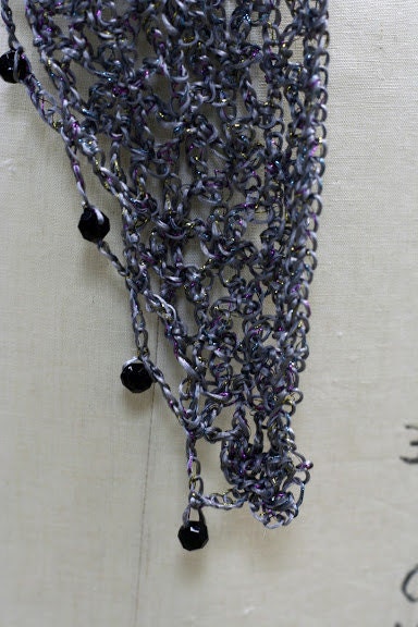 Side view of the gray shawl, the shimmering thread catching the light.