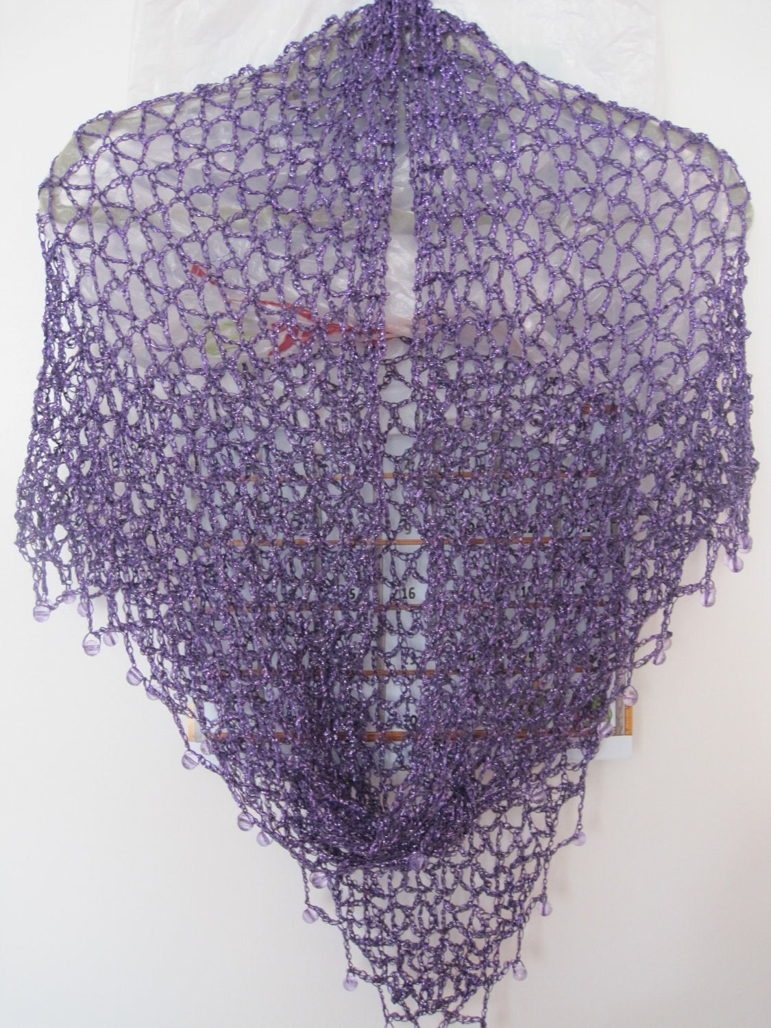 Detail of the hand stitches along the beaded edge of the plum purple shawl.