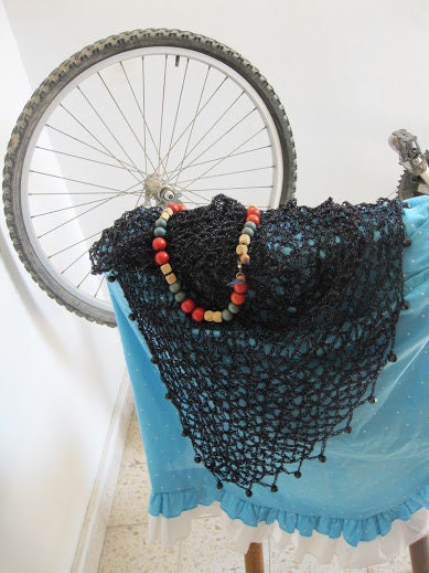 Side view of the black shawl, the shimmering thread catching the light.