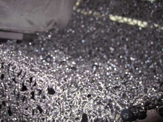 Black shawl laid flat, showing the full triangular shape.