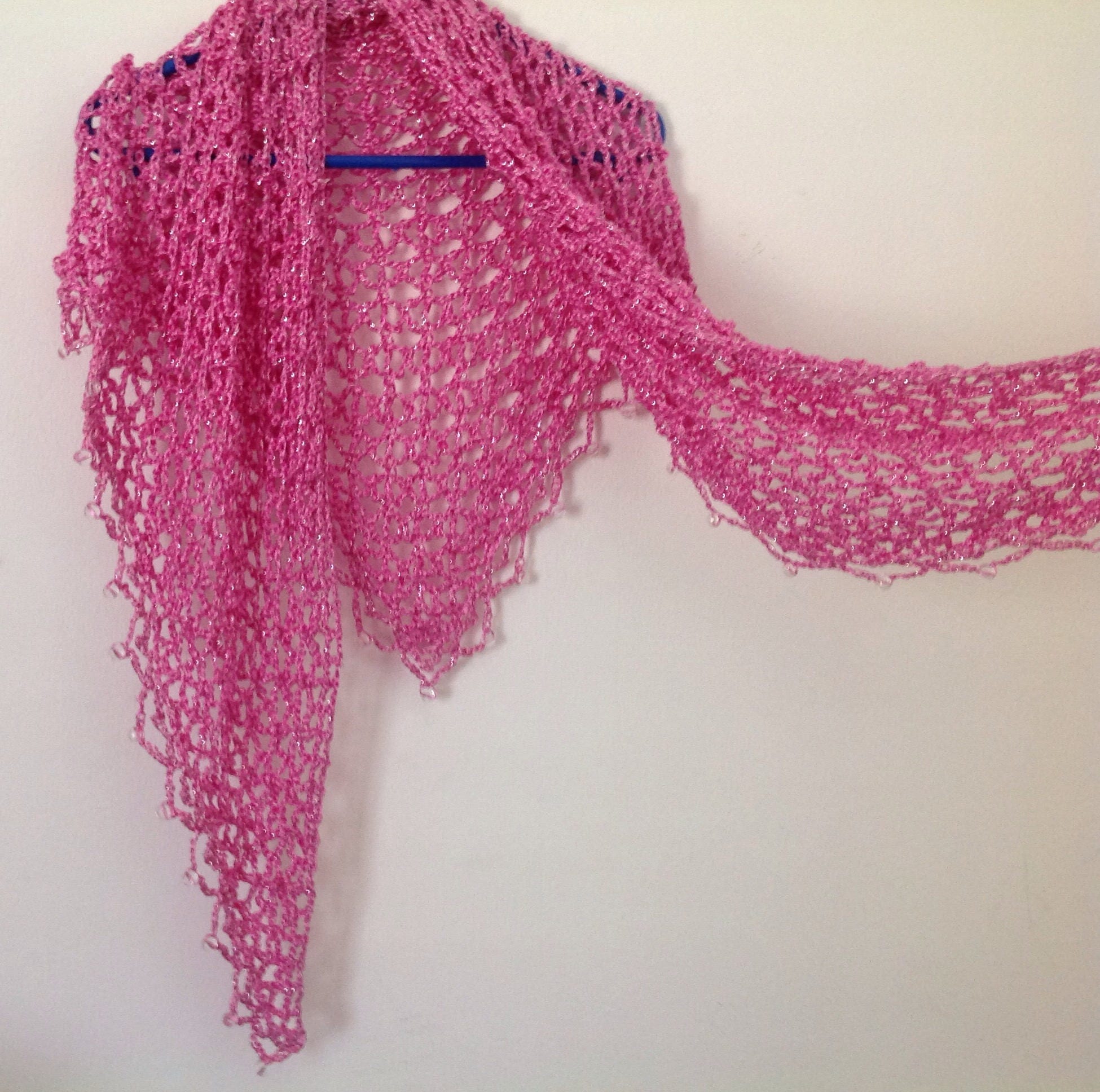 Side view of the blush pink shawl, the shimmering thread catching the light.