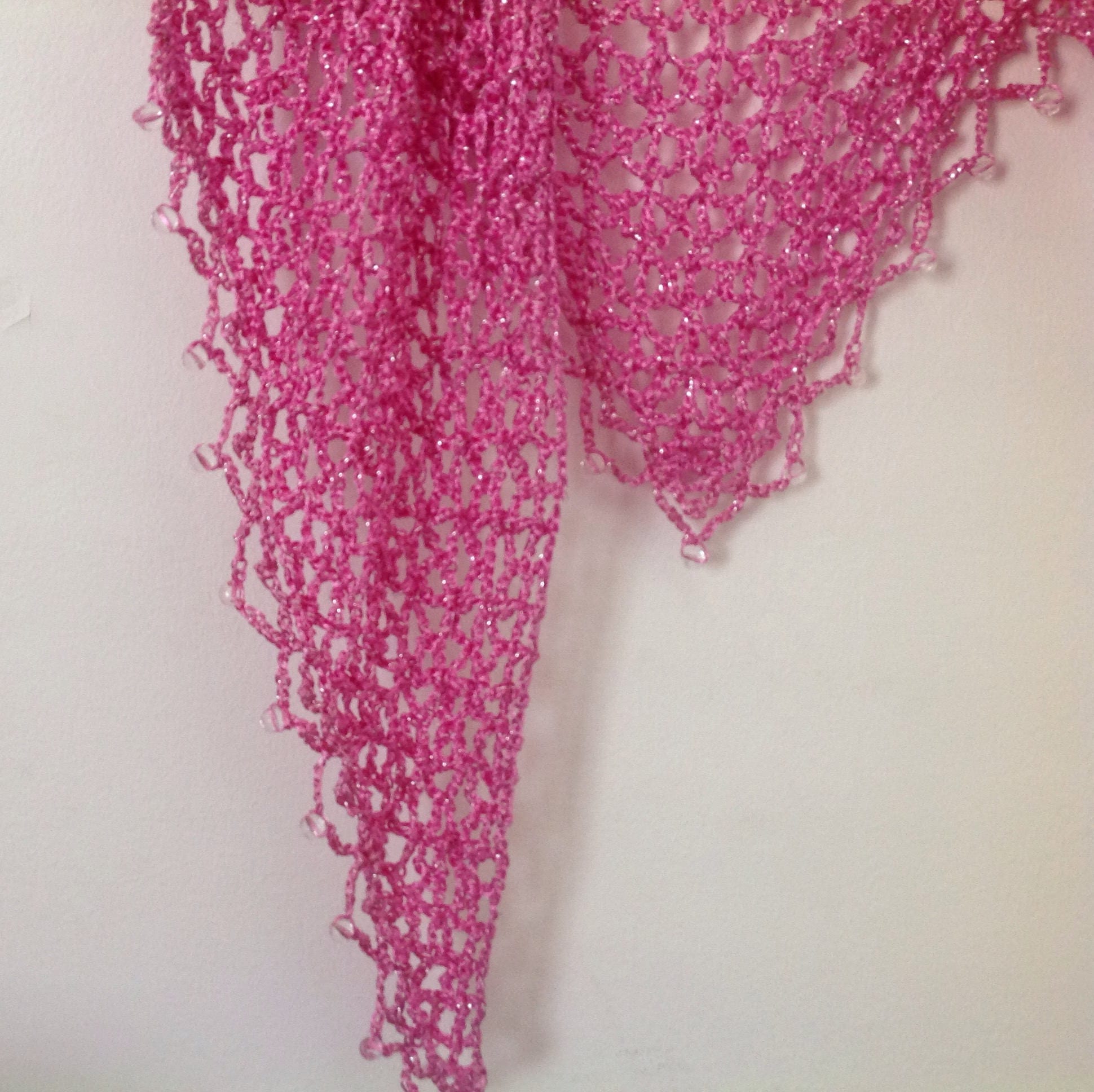 Close-up of the blush pink crochet openwork, small clear beads along the scalloped edge.