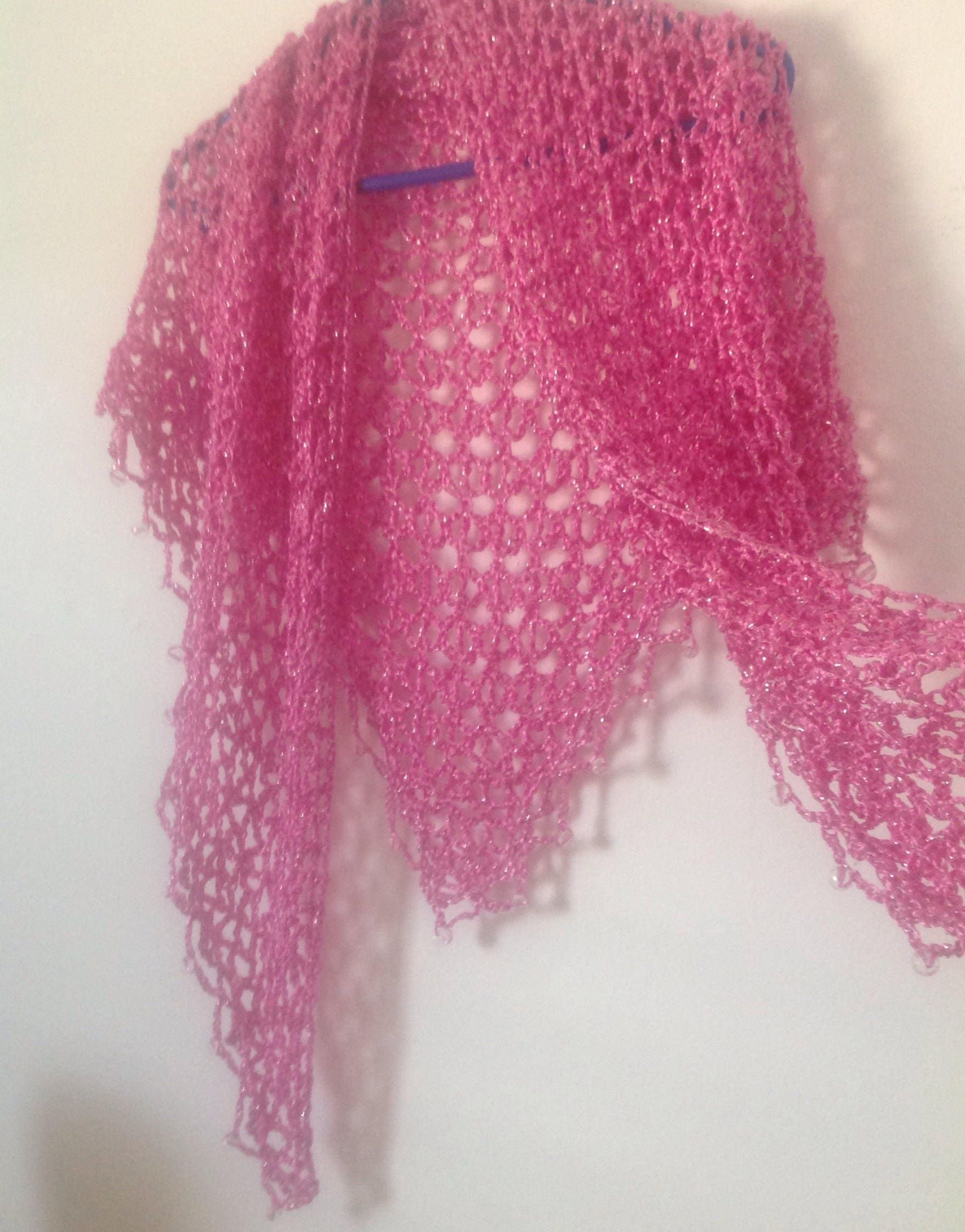 Blush pink shawl hanging open to show the full lacy body and beaded points.