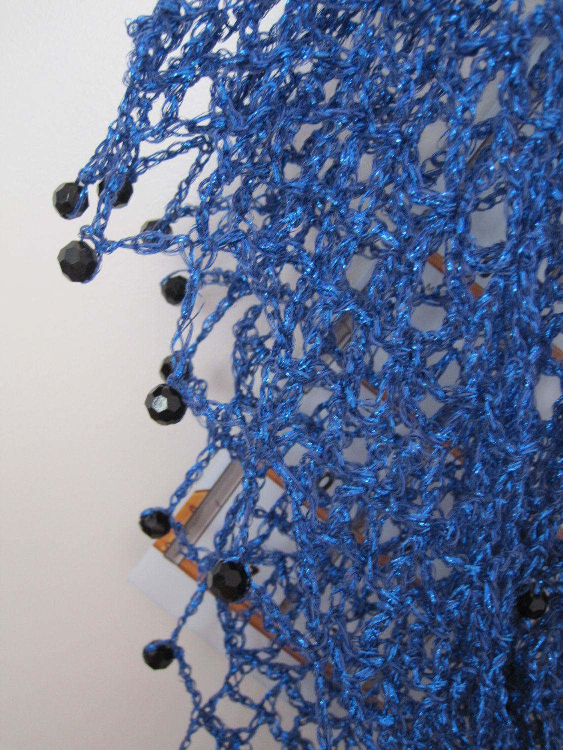 Close-up of the blue crochet openwork and beaded edge of the shawl.