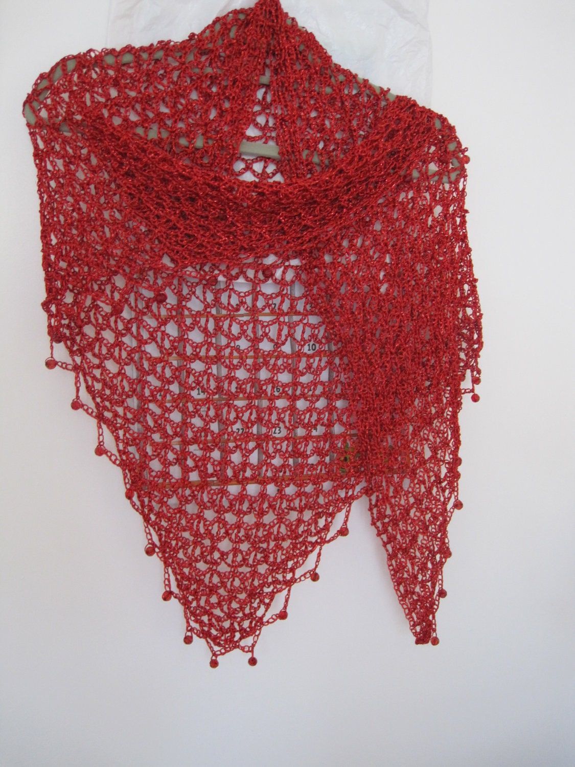 Close-up of the red crochet openwork and beaded edge of the shawl.