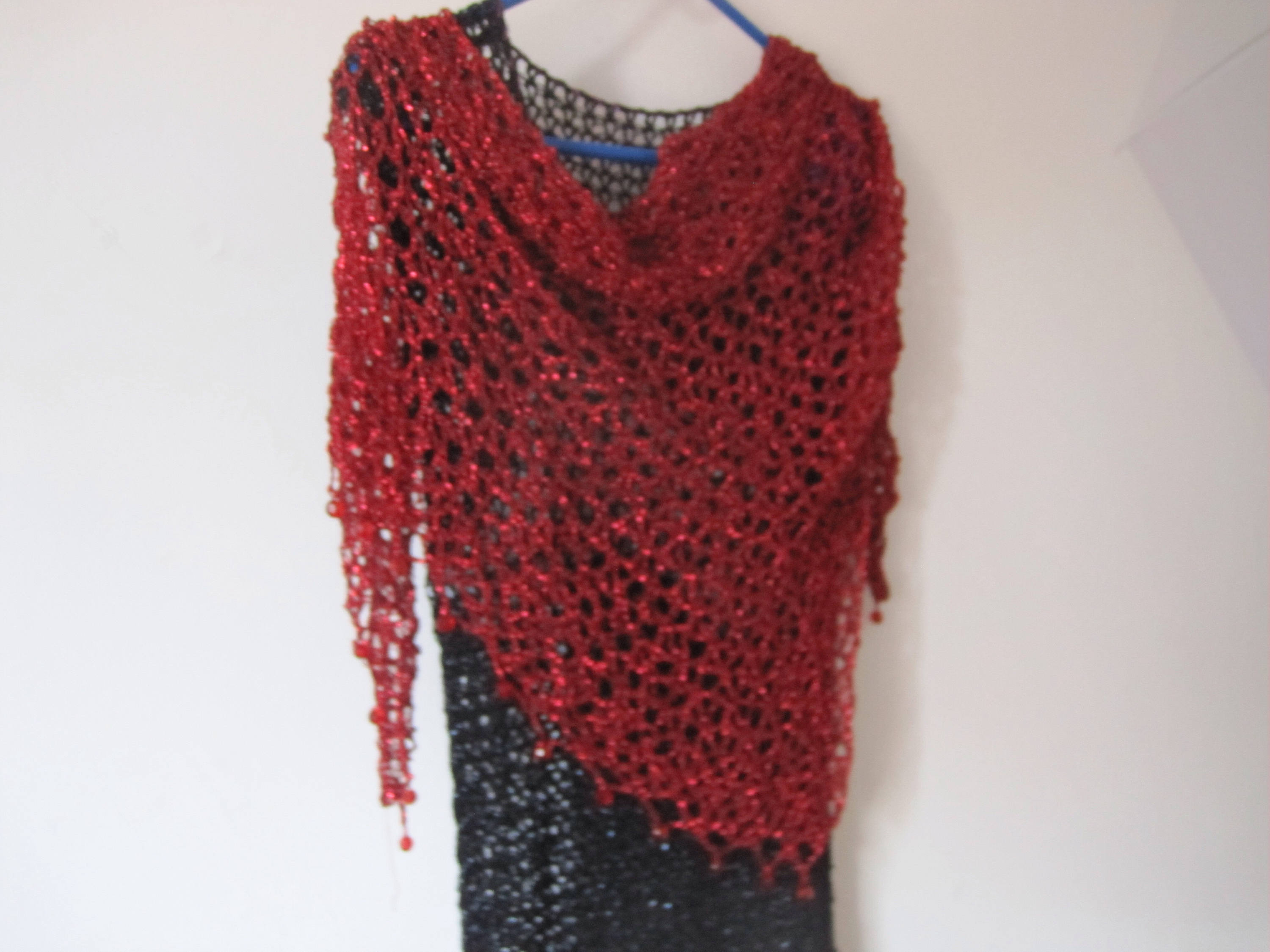 Detail of the hand stitches along the beaded edge of the red shawl.