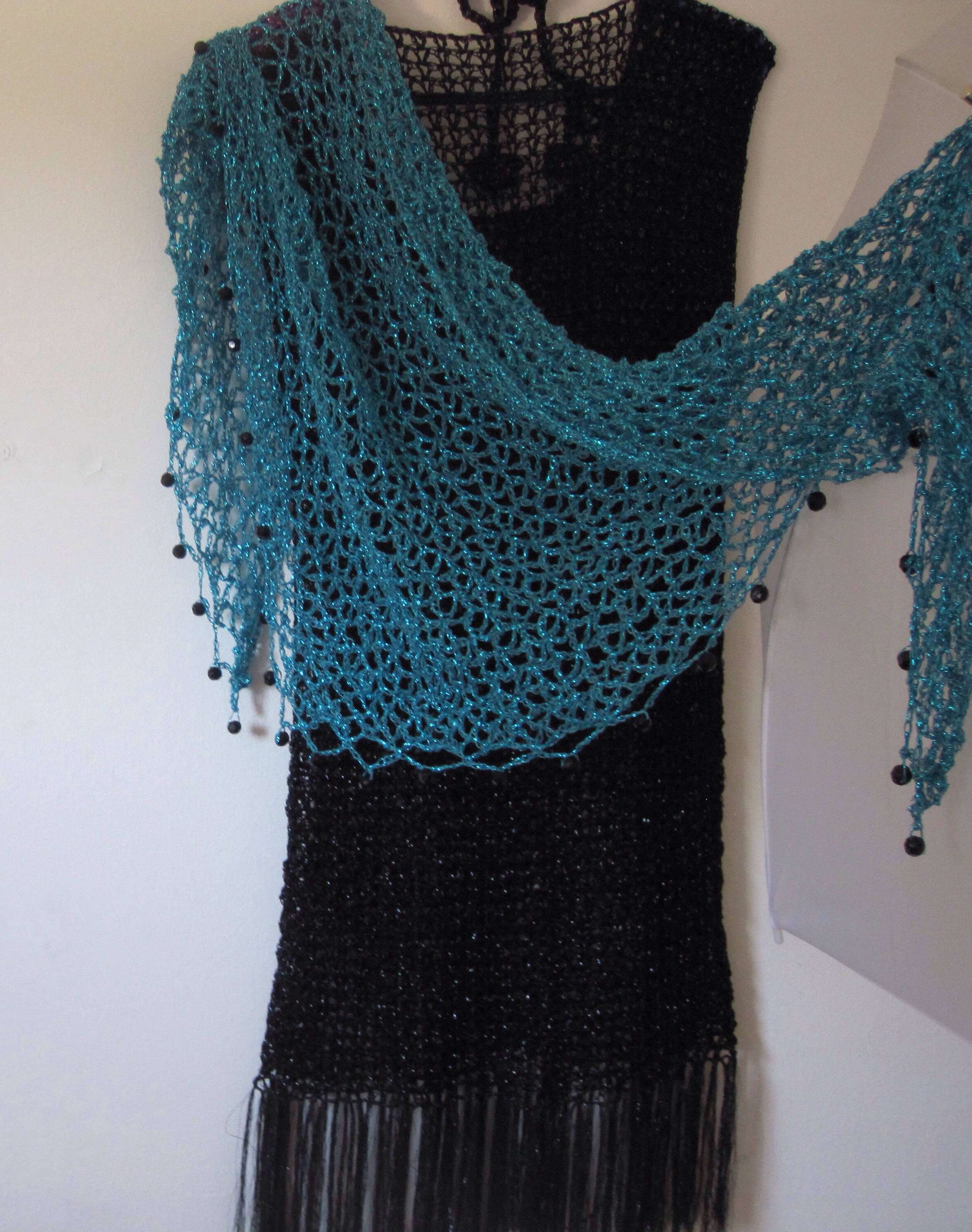 Side view of the turquoise shawl, the shimmering thread catching the light.