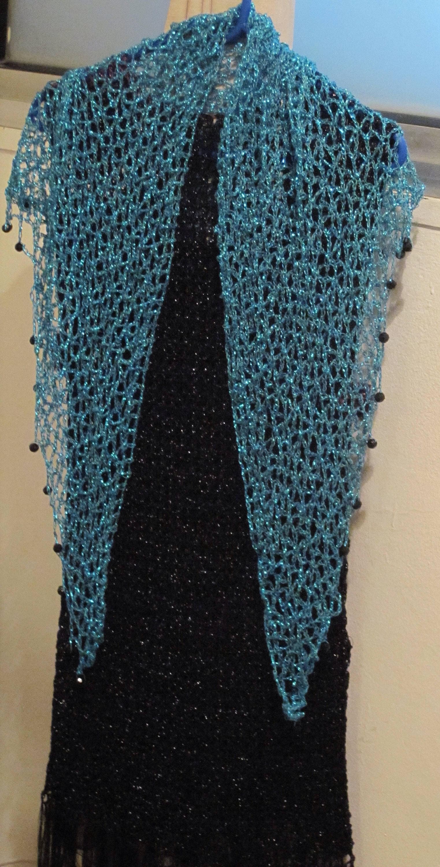 Detail of the hand stitches along the beaded edge of the turquoise shawl.
