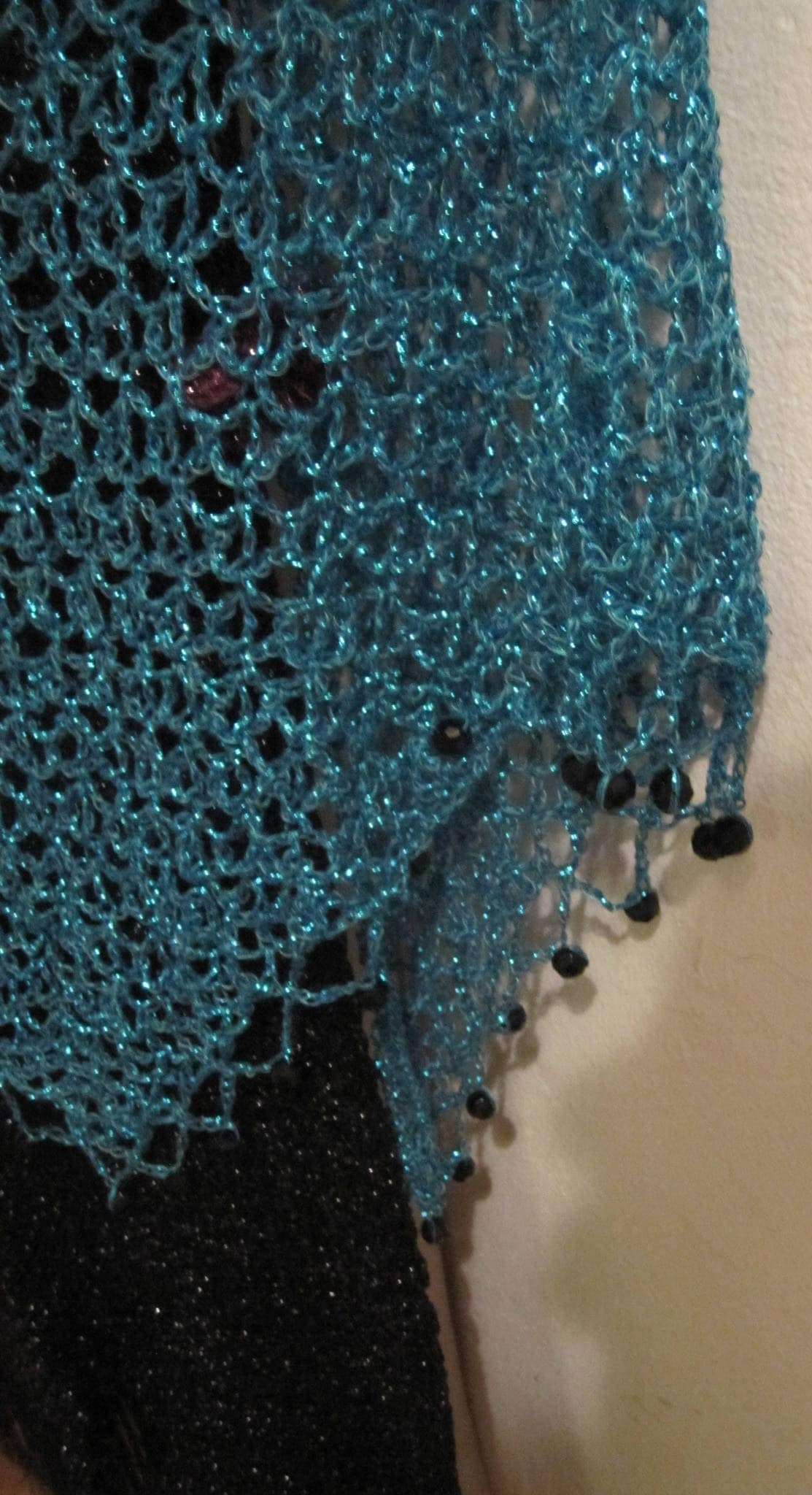 Turquoise shawl laid flat, showing the full triangular shape.
