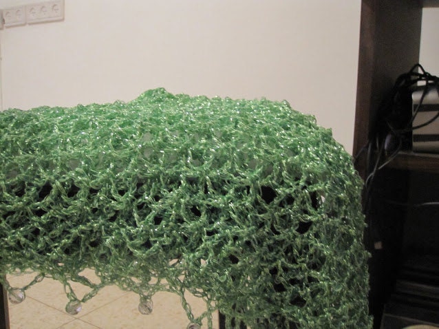 Close-up of the green crochet openwork and beaded edge of the shawl.