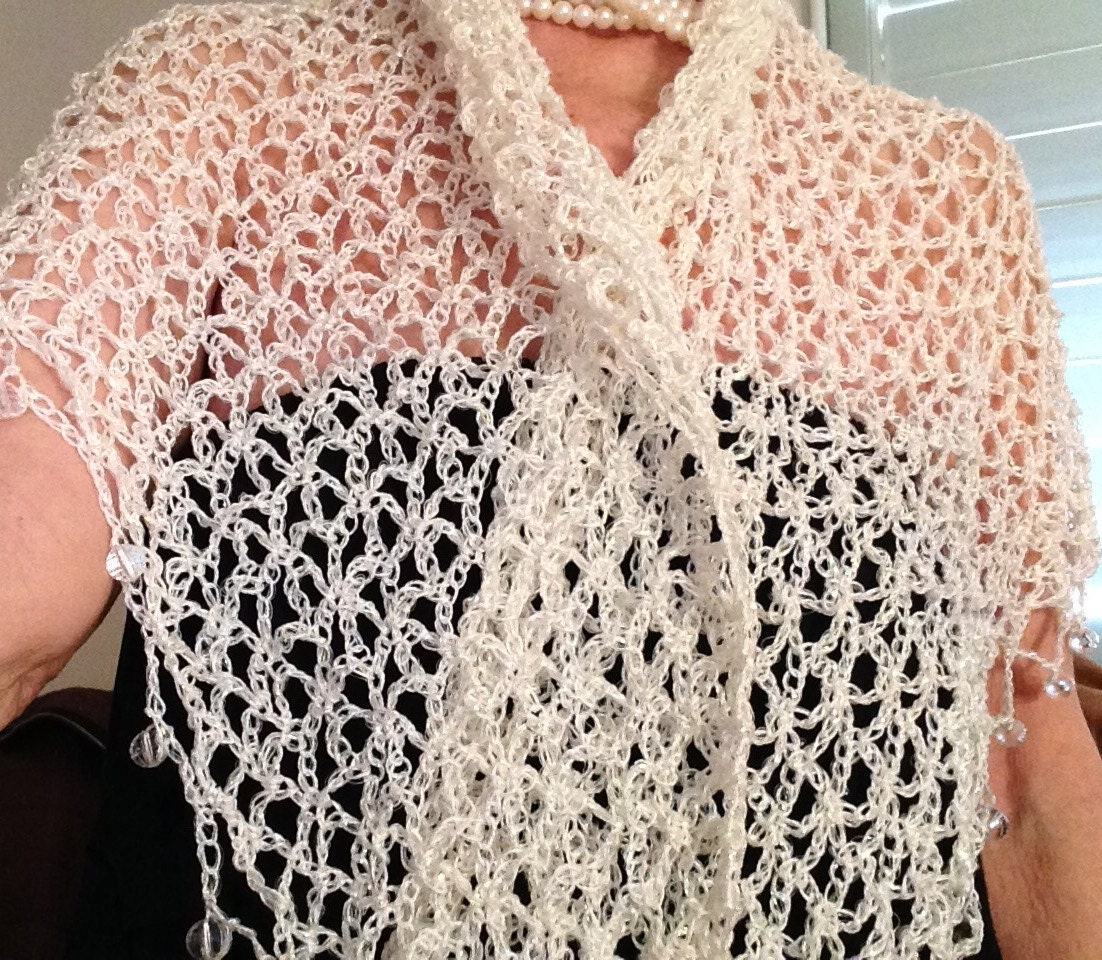 Close-up of the white crochet openwork and beaded edge of the shawl.