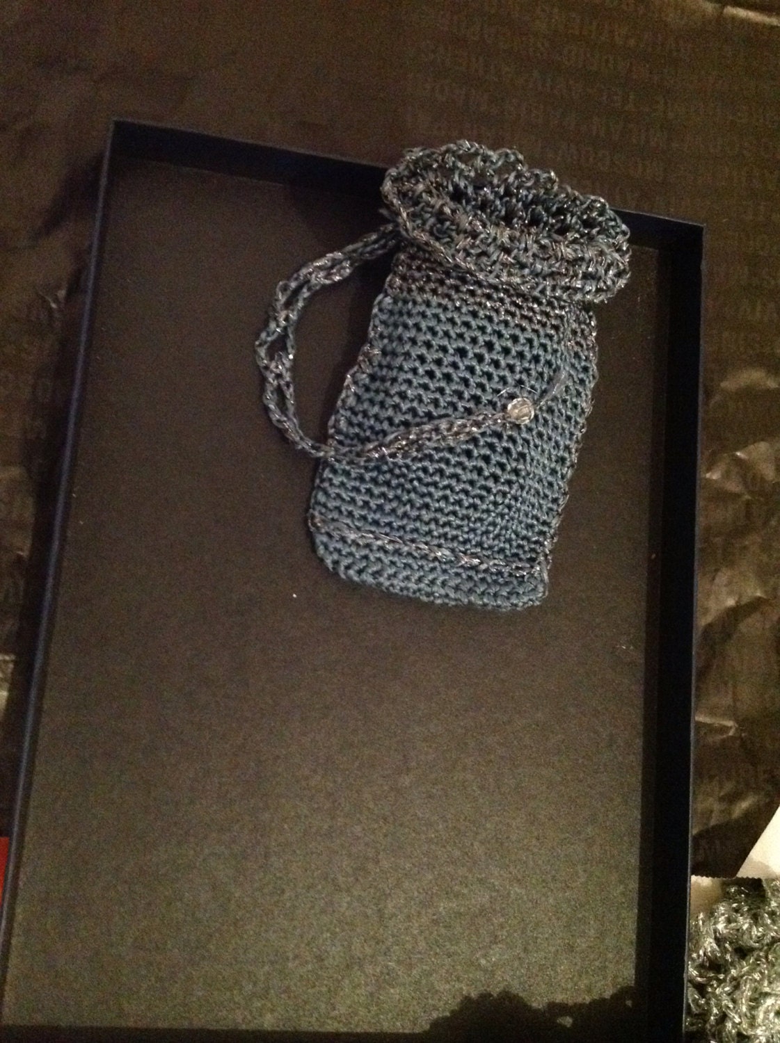 Close-up of the gray crochet openwork and beaded edge of the phone pouch.