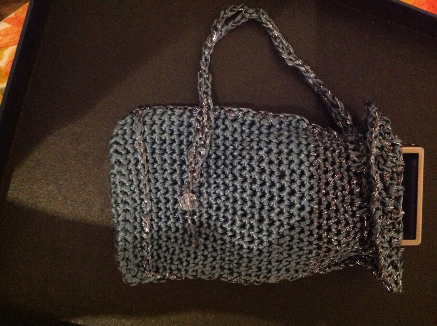 Detail of the hand stitches along the beaded edge of the gray phone pouch.