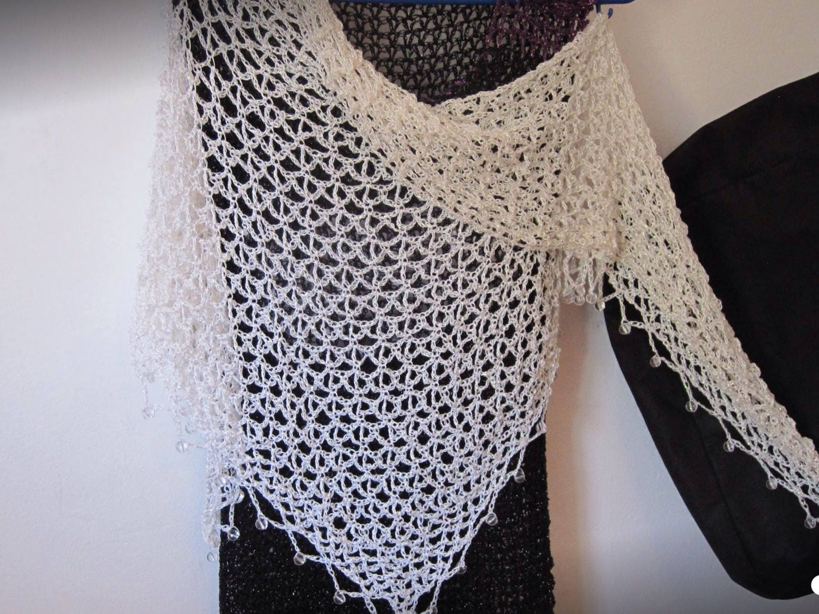 Side view of the cream shawl, the shimmering thread catching the light.