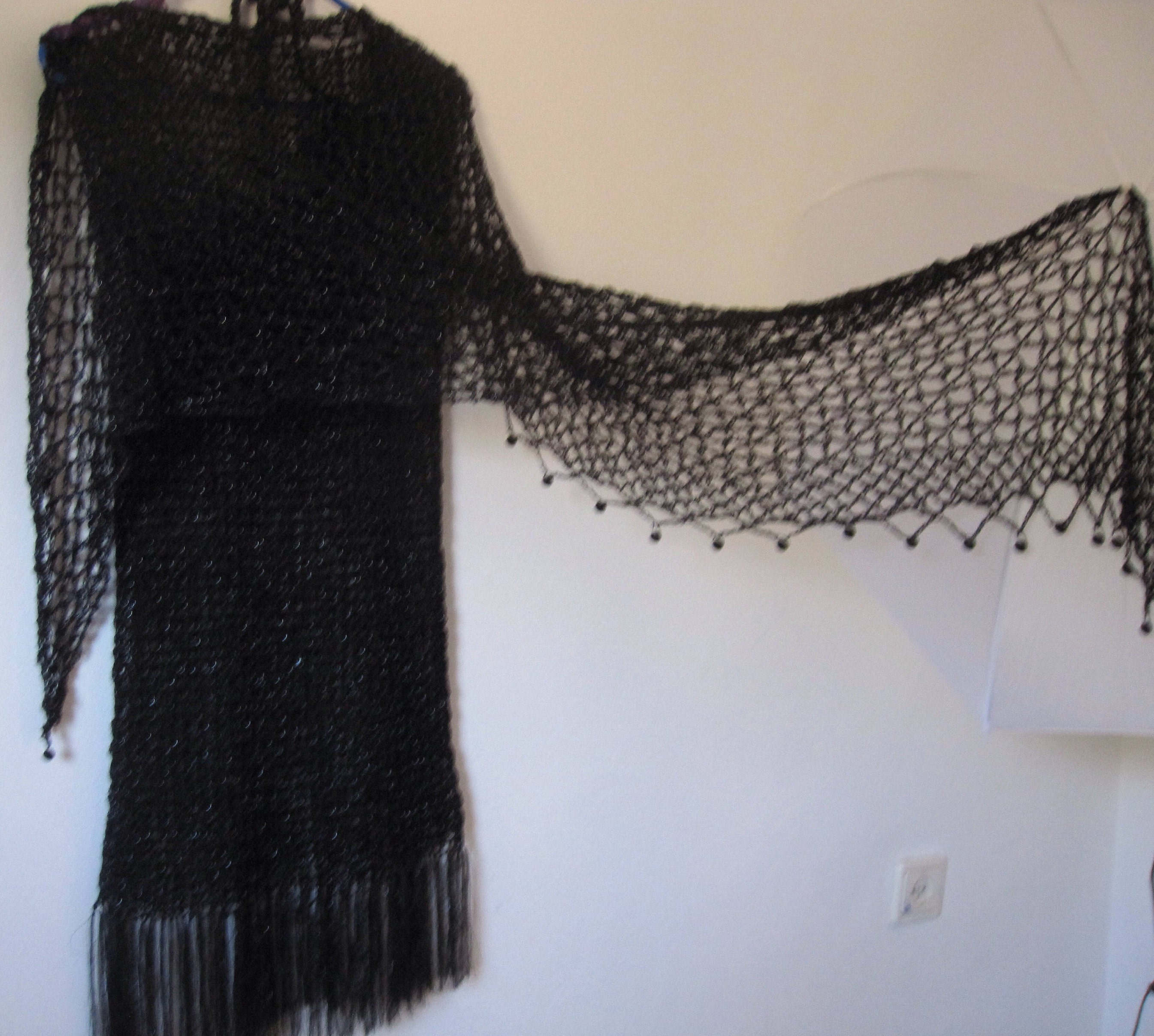 Side view of the black shawl, the shimmering thread catching the light.
