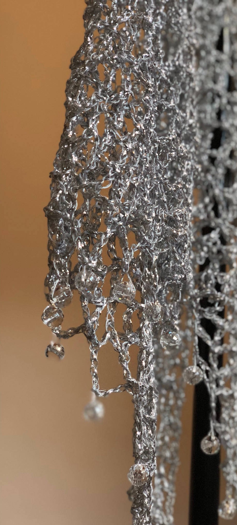 Close-up of the silver crochet openwork and beaded edge of the shawl.