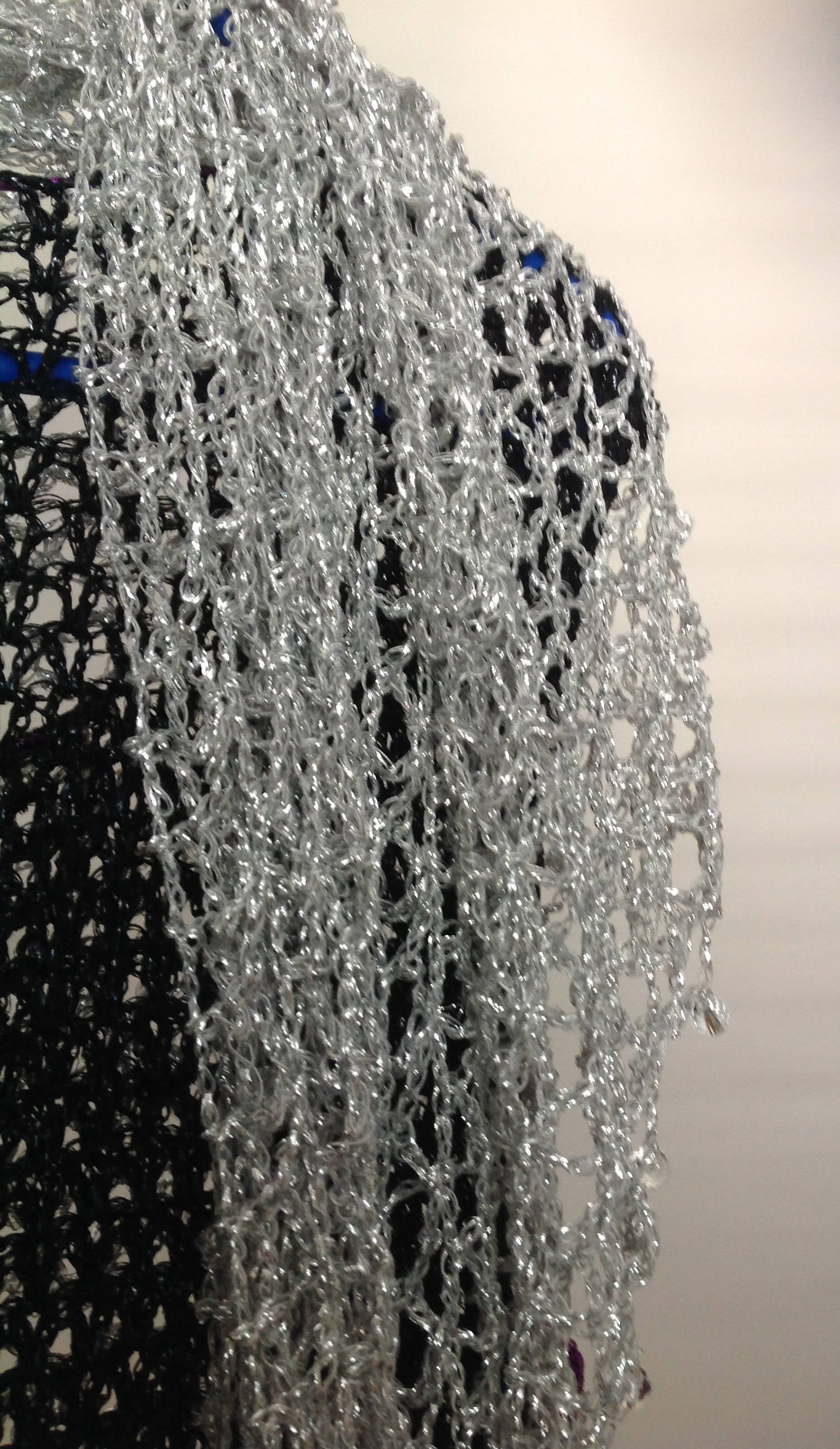Silver shawl laid flat, showing the full triangular shape.