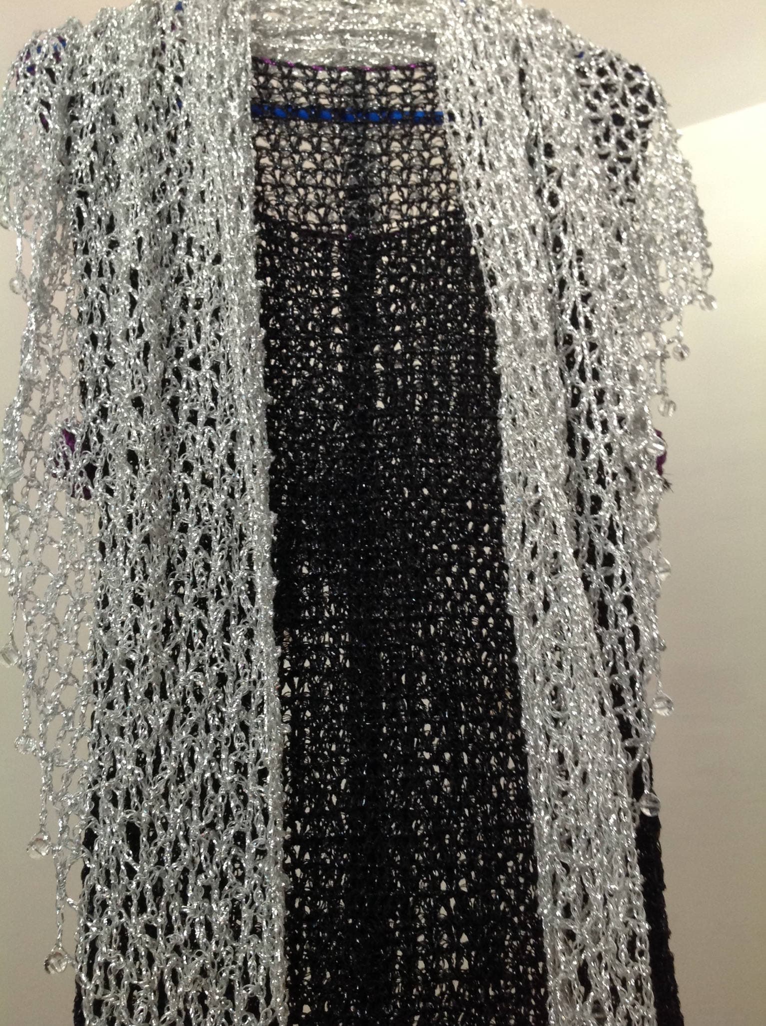 The silver shawl worn over the shoulders, front view.