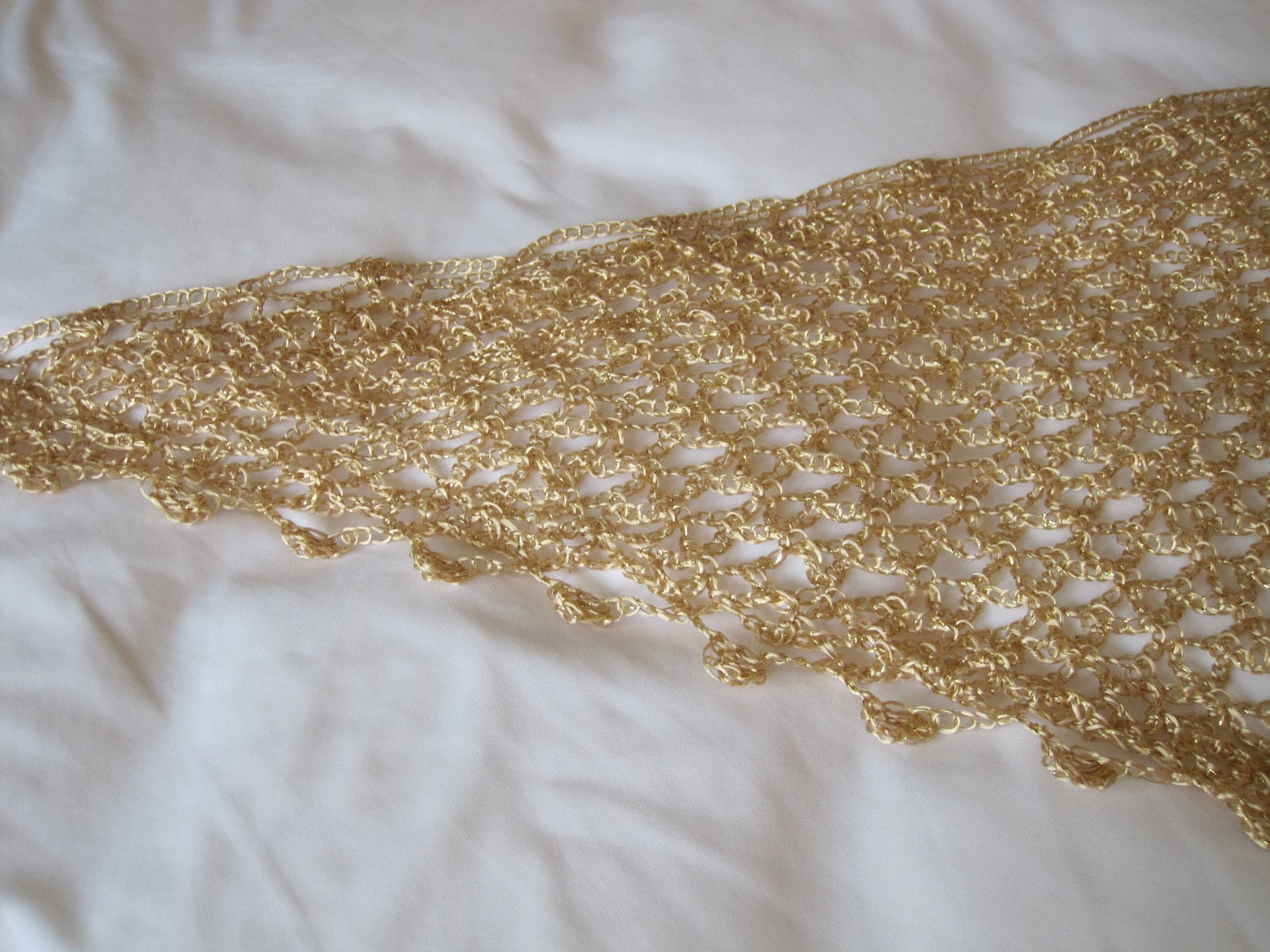 Detail of the hand stitches along the beaded edge of the gold shawl.